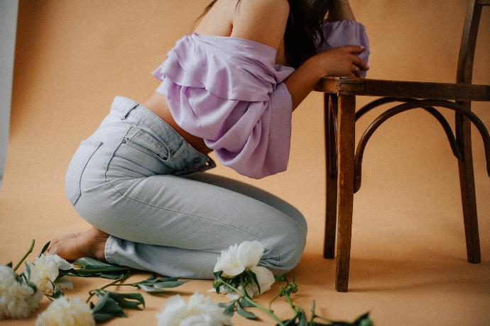 a woman sitting on a chair with flowers around her